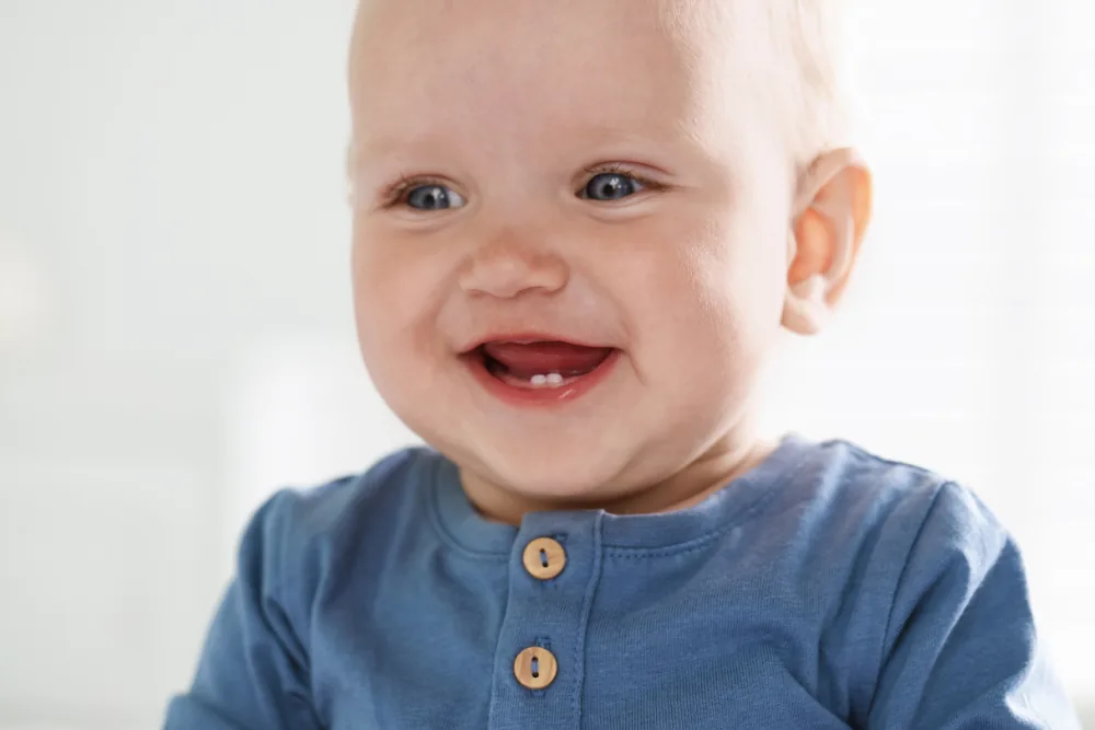 Smiling baby with first teeth beginning to come through