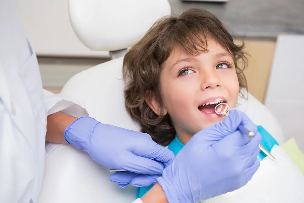 Child having their teeth checked by a dentist during a routine dental appointment