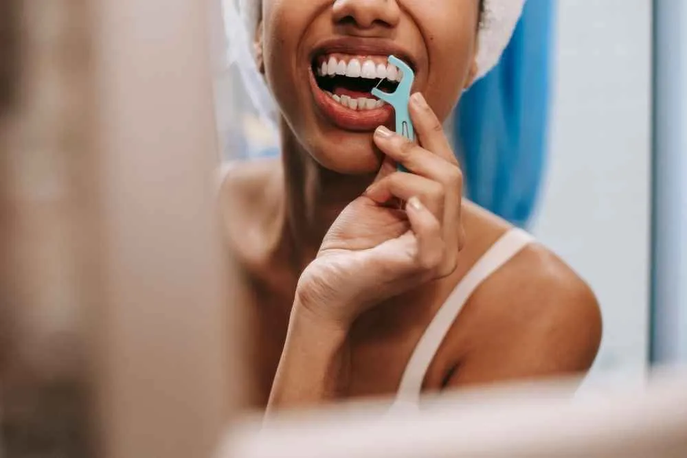 Patient cleaning between her teeth as part of daily dental care