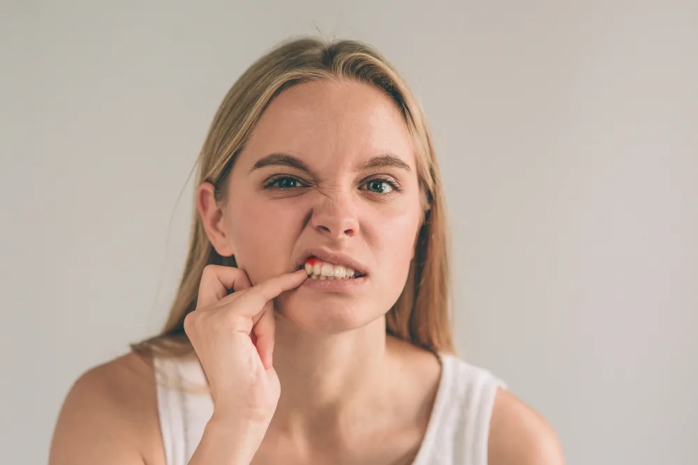 Woman checking sore or inflamed gums with her finger