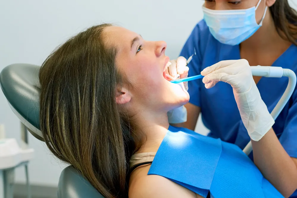 Dental hygienist professionally cleaning a patient's teeth