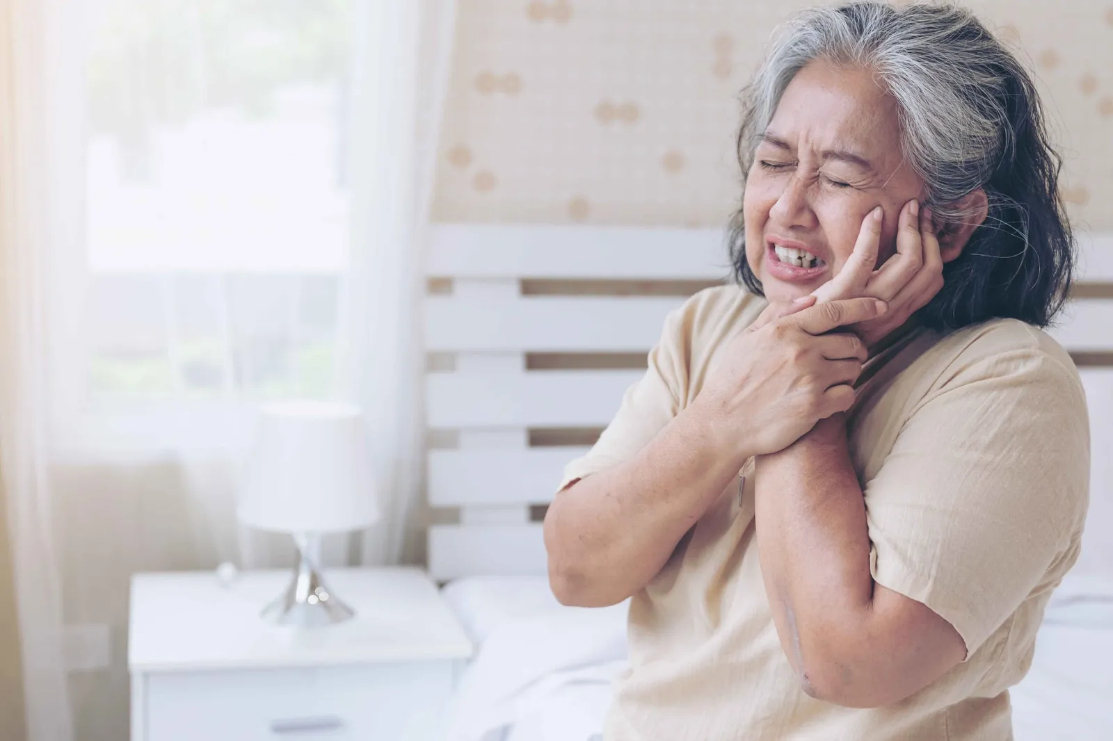 Woman experiencing severe toothache and jaw pain