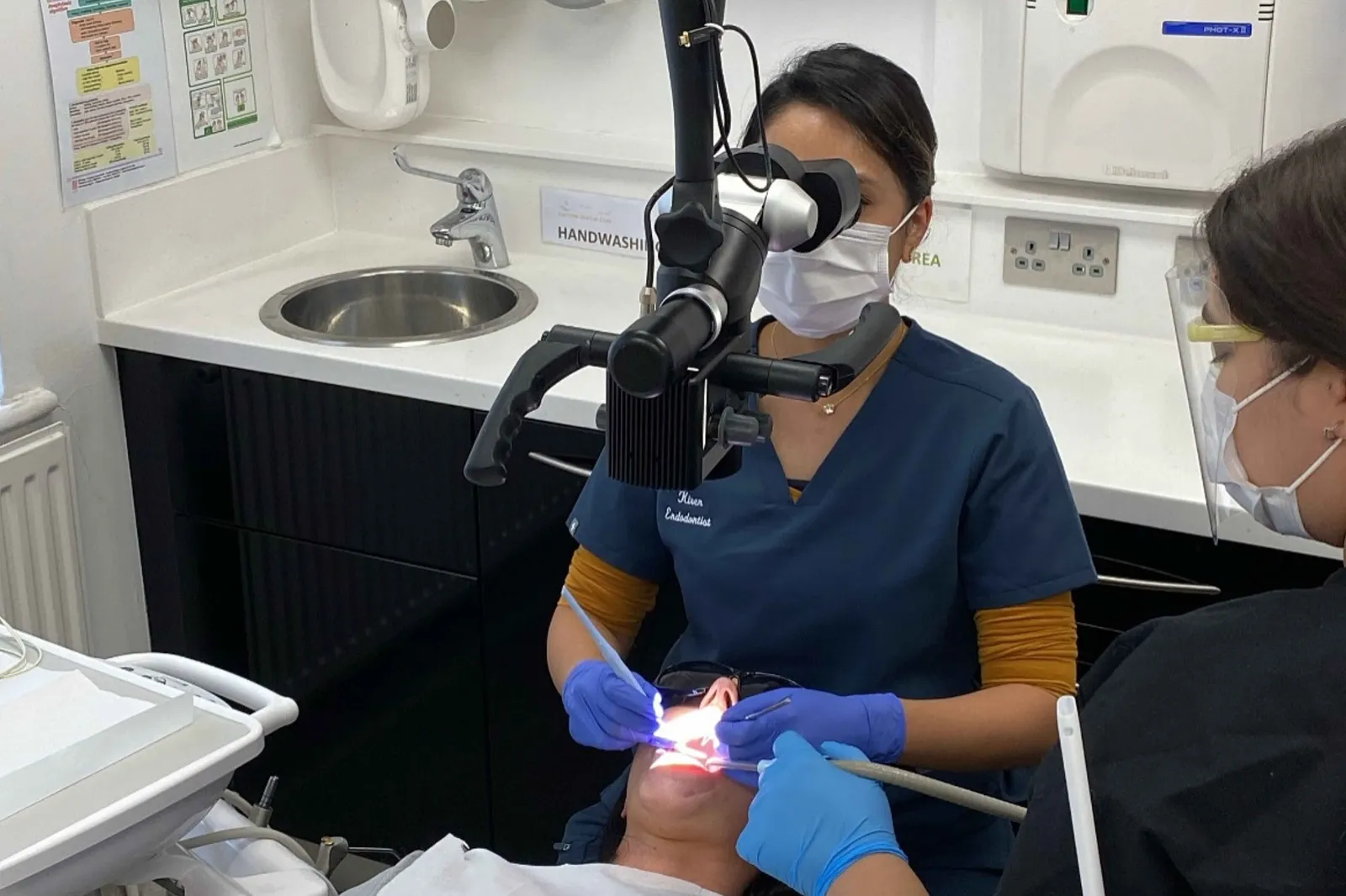 Endodontist at Hacton Dental Care using a dental microscope during specialist root canal treatment