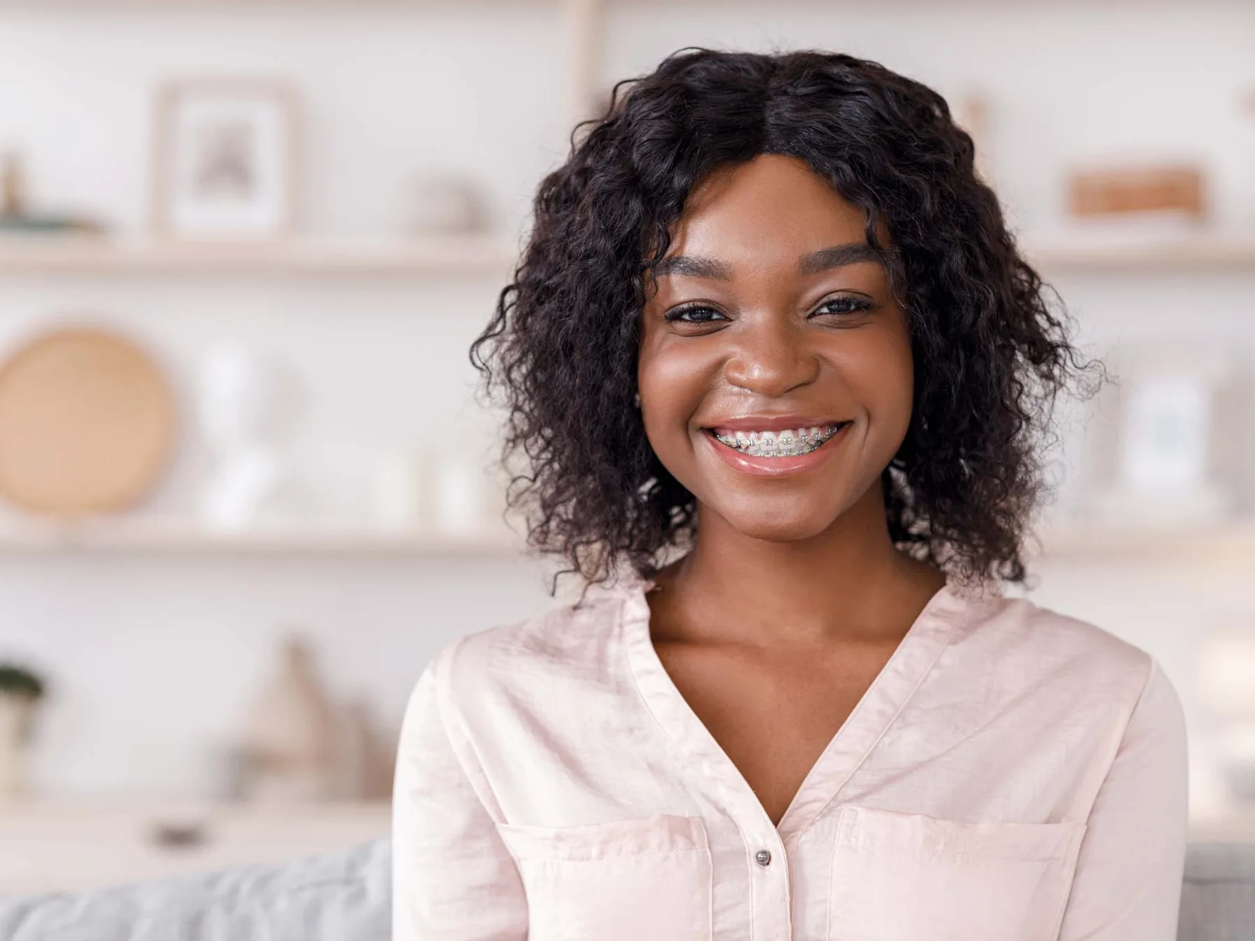 Smiling patient wearing fixed braces with visible brackets on her teeth
