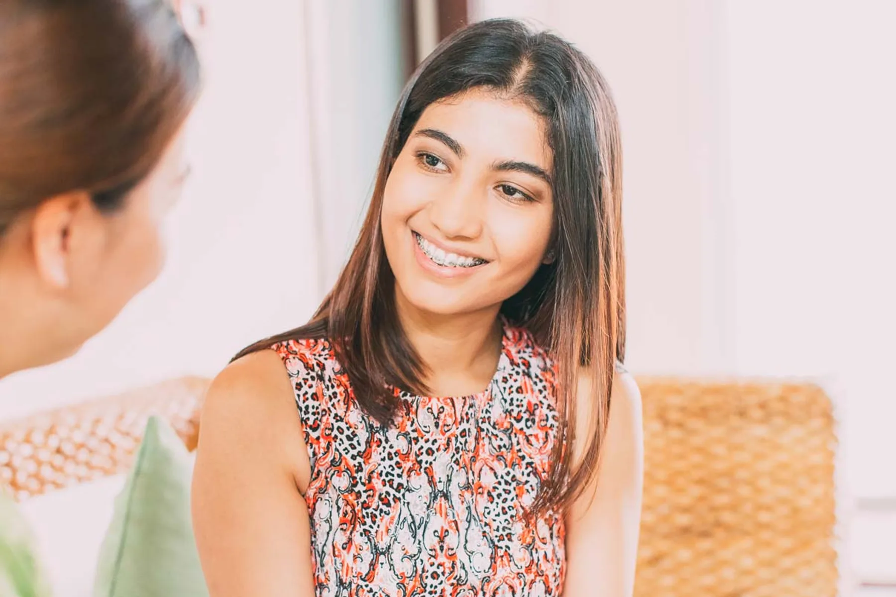 Young patient wearing fixed braces smiling during an orthodontic consultation